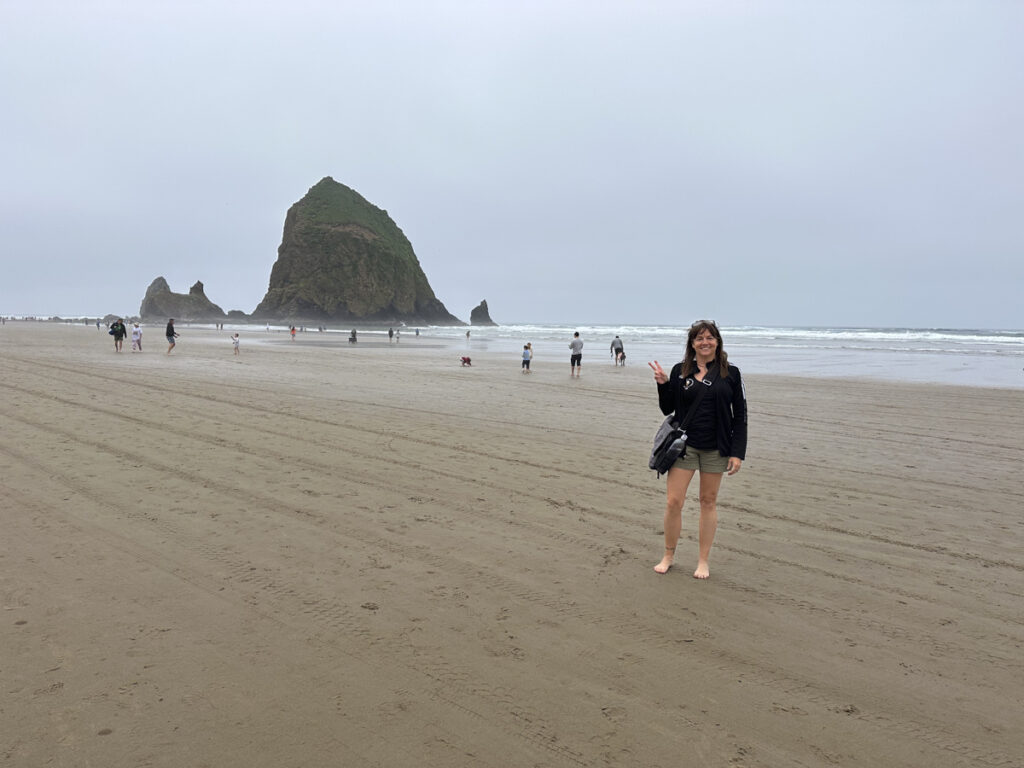 Woman standing in front of Haystack Rock. 