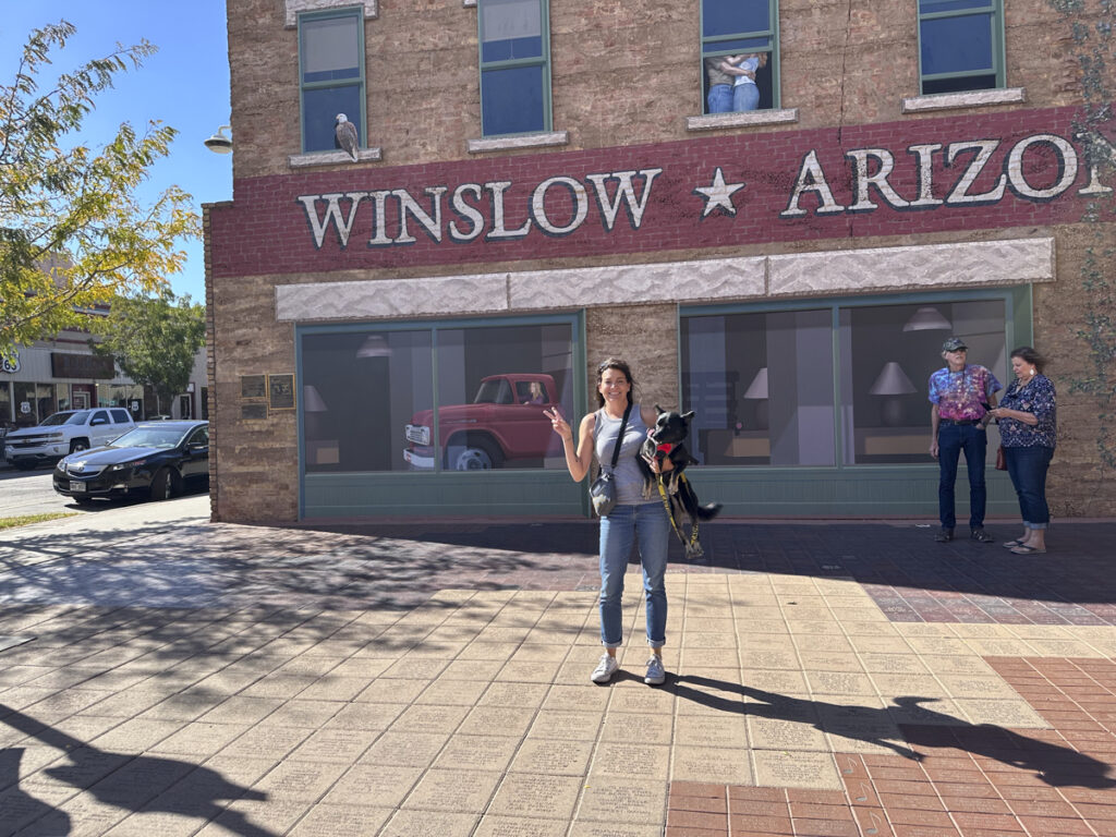 Person and her dog standing on a corner in Winslow, AZ. 